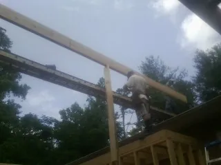 Carpenter setting a ridge beam over a new addition frame — Ice Dam Removal by Roofing Brothers in Lacygne