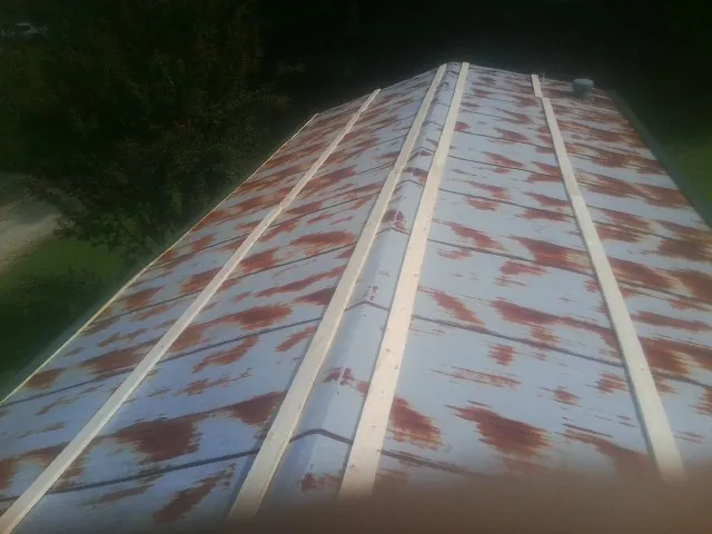 Rusted metal roof panels with new wood purlins before replacement — Storm Damage Roof Repair in Lacygne by Roofing Brothers